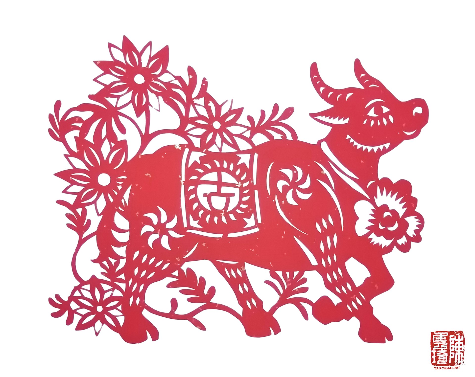 牛的剪纸。牛的颈项套着一朵大红花，背上的坐垫秀着「吉」字；牛正在很自信地往前（右边）走着，四周绽放着红花。