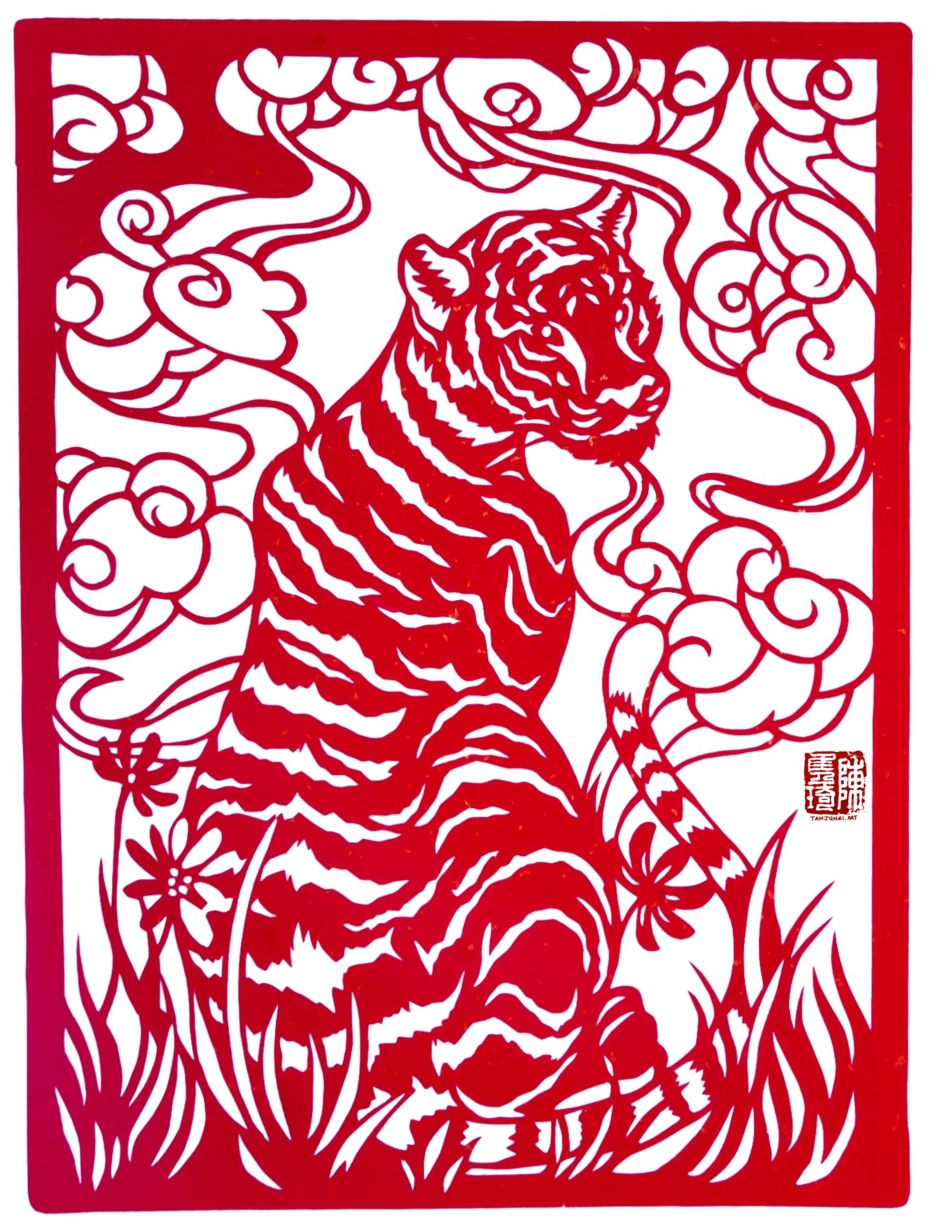 Chinese papercut with a rectangular frame; within it a tiger sits on the grass while lucky clouds roll overhead